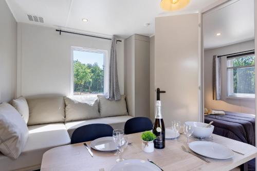 a living room with a table and a couch at Mobilehome Vallon 57 in Saint-Gervais