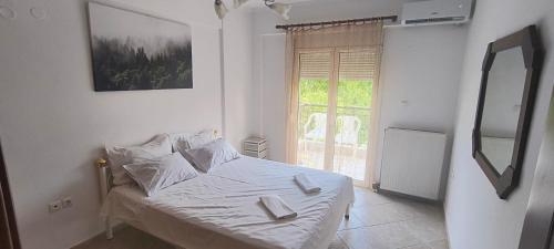 a bedroom with a bed with two books on it at DESPOINA APARTMENT 2 Relax in Nea Michaniona