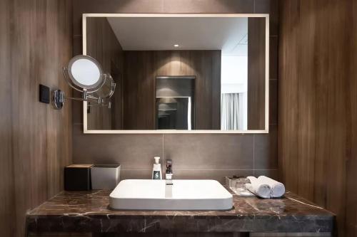 a bathroom with a white sink and a mirror at Atour Hotel Shuangyong Ave in Yan'an