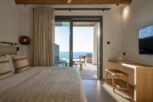 a bedroom with a bed and a view of the ocean at AOTO Villas in Kithnos