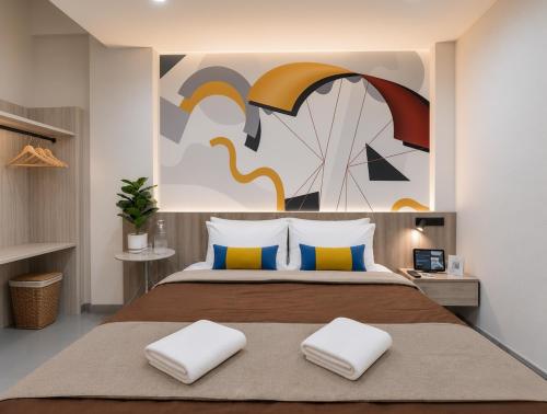 a bedroom with a bed with a painting on the wall at เดย์ อินน์ บาย วินด์แฮม ระยอง อู่ตะเภา in Ban Chang