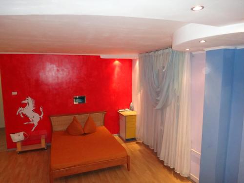 a red room with a couch and a red wall at Studio on Sovetskaya 206 in Biysk