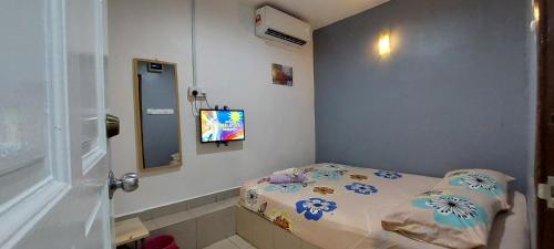 a small room with a bed and a television at LA MOTEL in Sungai Petani