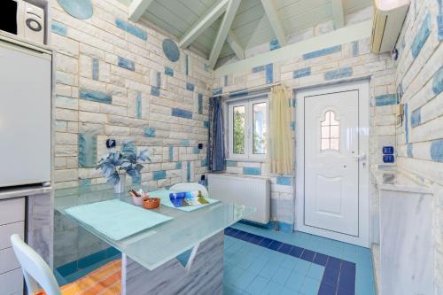 a kitchen with blue tiles and a white door at Paco's Resort Standard Studio 4 in Oziás