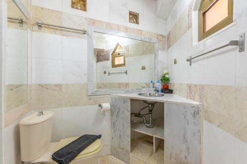 a bathroom with a sink and a toilet and a mirror at Paco's Resort Luxury Villa 19 in Oziás