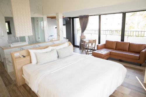 a bedroom with a large white bed and a kitchen at Wangan 175 B&B in Shui-wa-chüeh