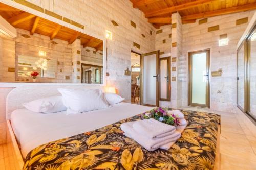 a bedroom with a large bed with towels on it at Paco's Resort Luxury Villa 19 in Oziás