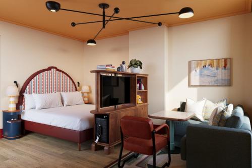 a bedroom with a bed and a tv and a couch at The July - Capel Street in Dublin