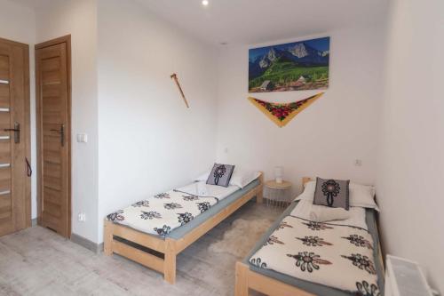 a room with two twin beds and a door at Apartament i Pokoje u Moniki in Witów