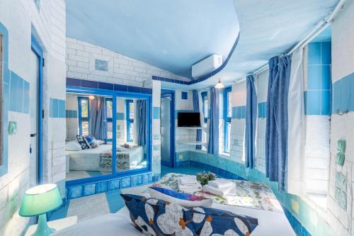 a blue and white room with a bed and a mirror at Paco's Resort Superior Villa 6 in Oziás