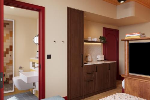 a bathroom with a sink and a toilet and a television at The July - Capel Street in Dublin