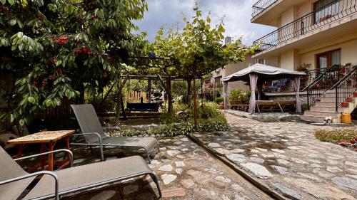 a patio with chairs and a gazebo next to a building at Dima Suites Bansko - Vihren view & free parking in Bansko