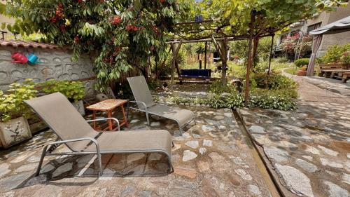 two chairs and a table in a garden at Dima Suites Bansko - Vihren view & free parking in Bansko
