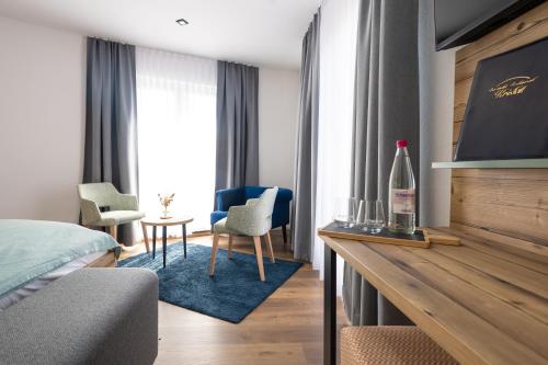 a hotel room with a bed and a table and chairs at Berghotel Kristall in Idar-Oberstein