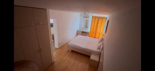 a small room with a bed and a window at Hotel Nora in Zajmovo