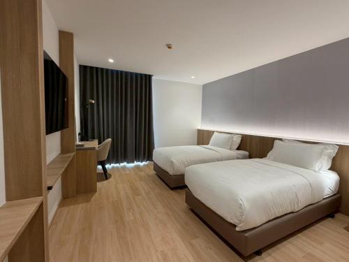 ein Hotelzimmer mit zwei Betten und einem Schreibtisch in der Unterkunft Mehtan Hotel in Mae Sot