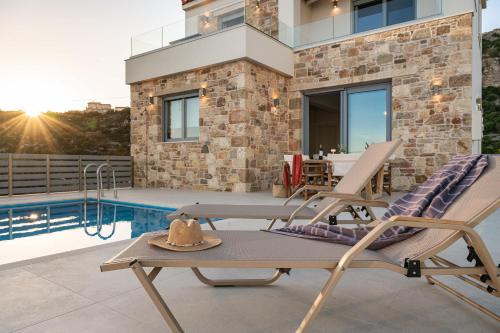 a patio with a chair and a table and a pool at Villa Alexia - Private Pool & Panoramic Sea Views in Órmos Koumaíïkon