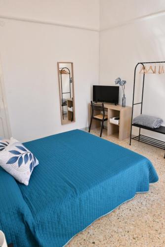 a bedroom with a blue bed and a desk at Donna Lina Home- Enjoy Apulia in Monopoli