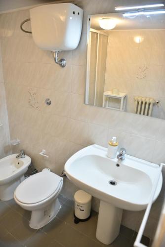 a bathroom with a sink and a toilet and a mirror at Donna Lina Home- Enjoy Apulia in Monopoli