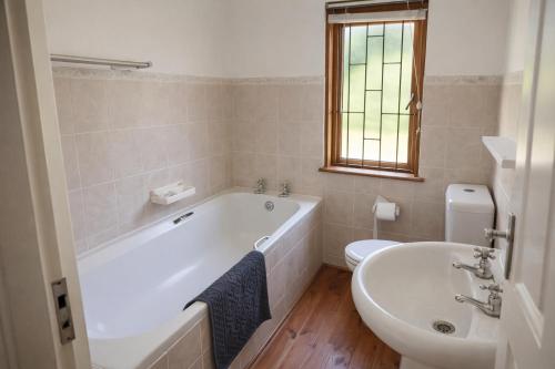 a bathroom with a tub and a toilet and a sink at Beach Cabin with a pool in Port Alfred