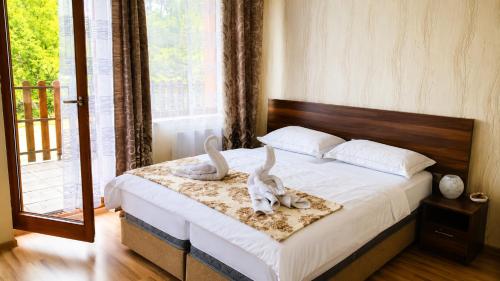 a bedroom with a bed with two rabbits on it at Apartmánový Garni Hotel Relax in Senec