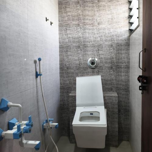 a bathroom with a white toilet in a room at Atithi Lodging in Ale