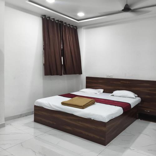 a bedroom with a bed with a wooden head board at Atithi Lodging in Ale