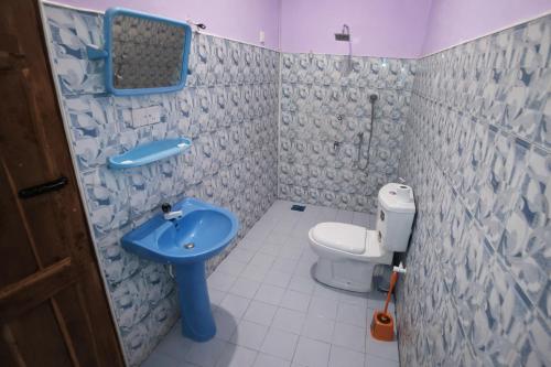 a bathroom with a blue sink and a toilet at East Breeze in Arugam Bay