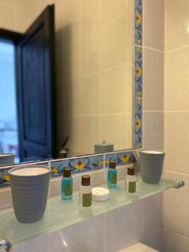 a shelf in a bathroom with a mirror and bowls at Hotel Villa Tokur in Datca