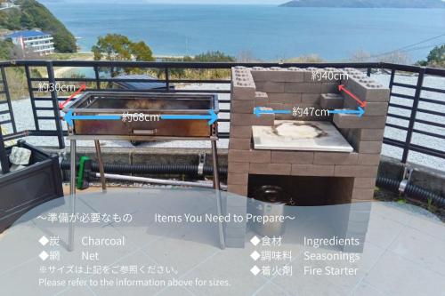 a grill on top of a balcony with a view of the ocean at Sunrise Resort Aji in Takamatsu
