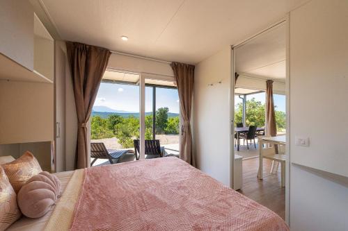 a bedroom with a bed and a view of a patio at Vela Stina Mobile home in Roč