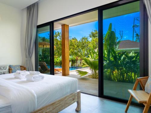 a bedroom with a bed and a view of a pool at Enchanting Villa Namaste 3Br Private Pool & Garden in Nathon Bay