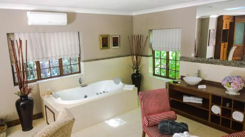 a large bathroom with a tub and a sink at Edenbrook Country Manor in Plettenberg Bay