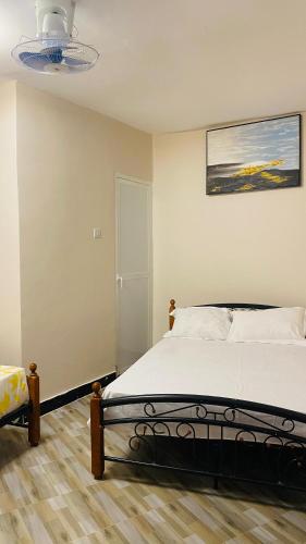 a bedroom with a bed and a painting on the wall at Varine House in Dodoma