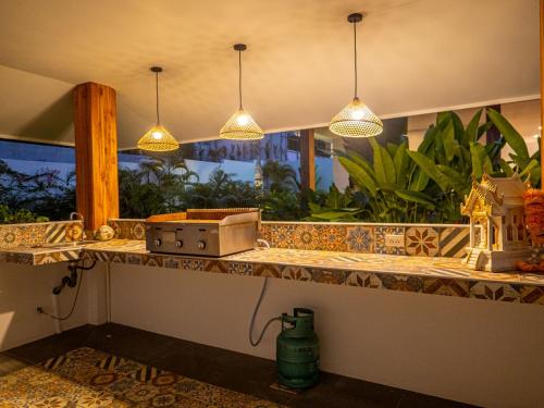 a kitchen counter with pendant lights and a window at Enchanting Villa Namaste 3Br Private Pool & Garden in Nathon Bay