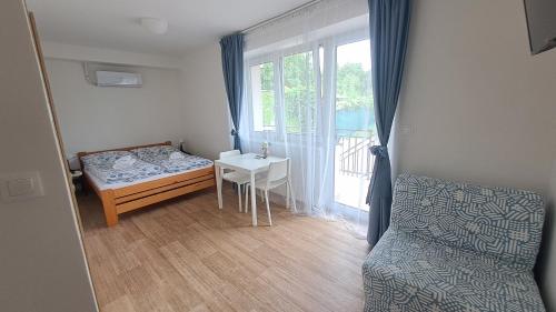 a bedroom with a bed and a table and a window at Valen apartmány Valtice in Valtice