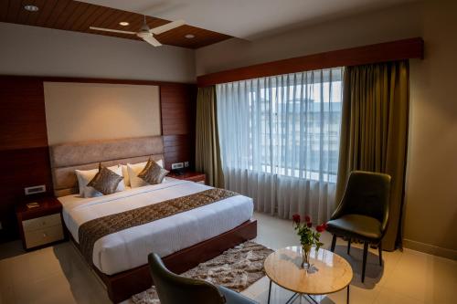 a hotel room with a bed and a large window at Luxo Wayanad in Sultan Bathery