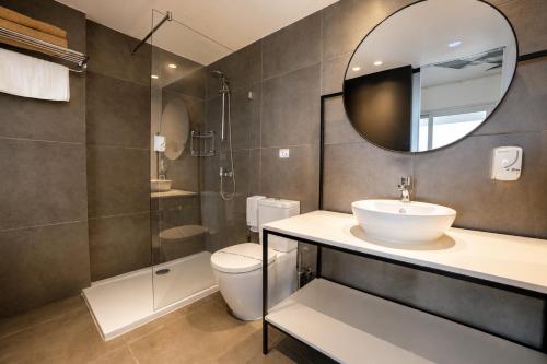 a bathroom with a sink and a toilet and a mirror at Anthea Hotel Apartments in Ayia Napa