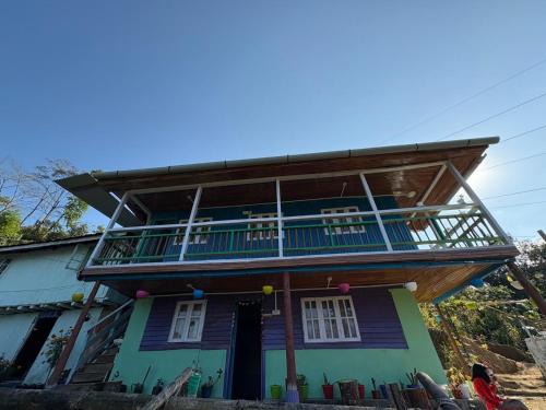 a house with a balcony on top of it at Karki Farm Stay in Bijanbāri Bāzār
