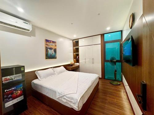 a bedroom with a bed and a flat screen tv at NBZ Homestay in Hanoi