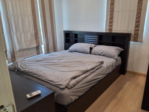 a bed with a black headboard in a room at The Plant Light Thiwanon in Lat Lum Kaeo