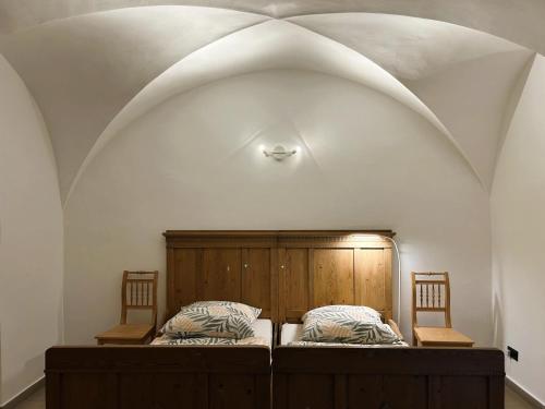 two beds in a room with an arched ceiling at Rittergut Hohenfichte Herrenhaus in Leubsdorf