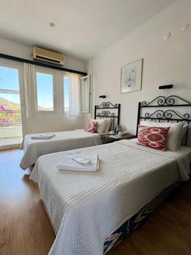 two beds in a hotel room with a window at Hotel Villa Tokur in Datca