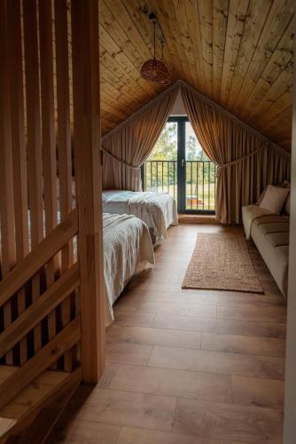 a bedroom with two beds and a couch in a room at Sploty Lasu u stóp Lubonia - Domki z Jacuzzi in Rabka-Zdrój