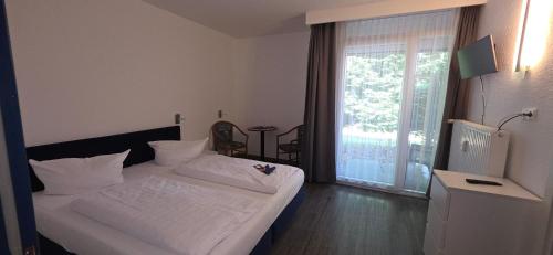 a hotel room with a bed and a balcony at Aparthotel Höper in Oyten
