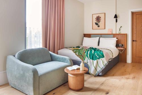 a bedroom with a bed and a blue chair at Turing Locke Cambridge in Cambridge