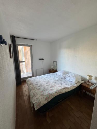 a bedroom with a large bed and a window at À Deux Pas de la Mer charmant T2 in Canet-en-Roussillon
