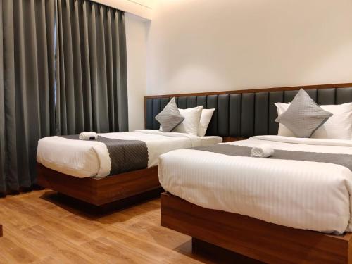 two beds in a hotel room withskirts at L G Cordial in Mysore