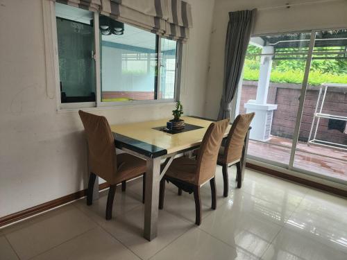 a dining room with a table and chairs and a window at The Plant Light Thiwanon in Lat Lum Kaeo