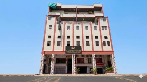 a large white building with a sign on it at Luxmi Hotel in Allahābād